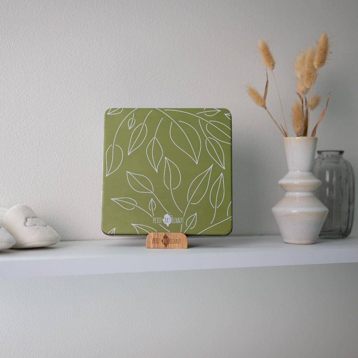 Petit Artichaut baby box square in olive tree print closed tin sitting on dresser