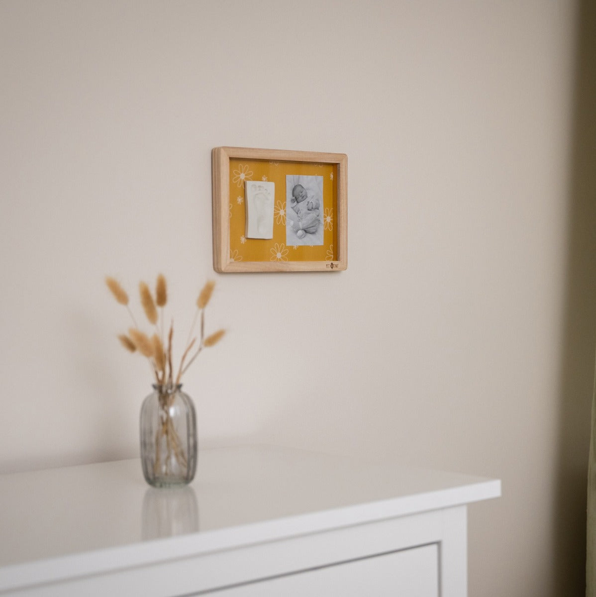 Petit Artichaut Classic Frame with daisy ochre print hung on the wall