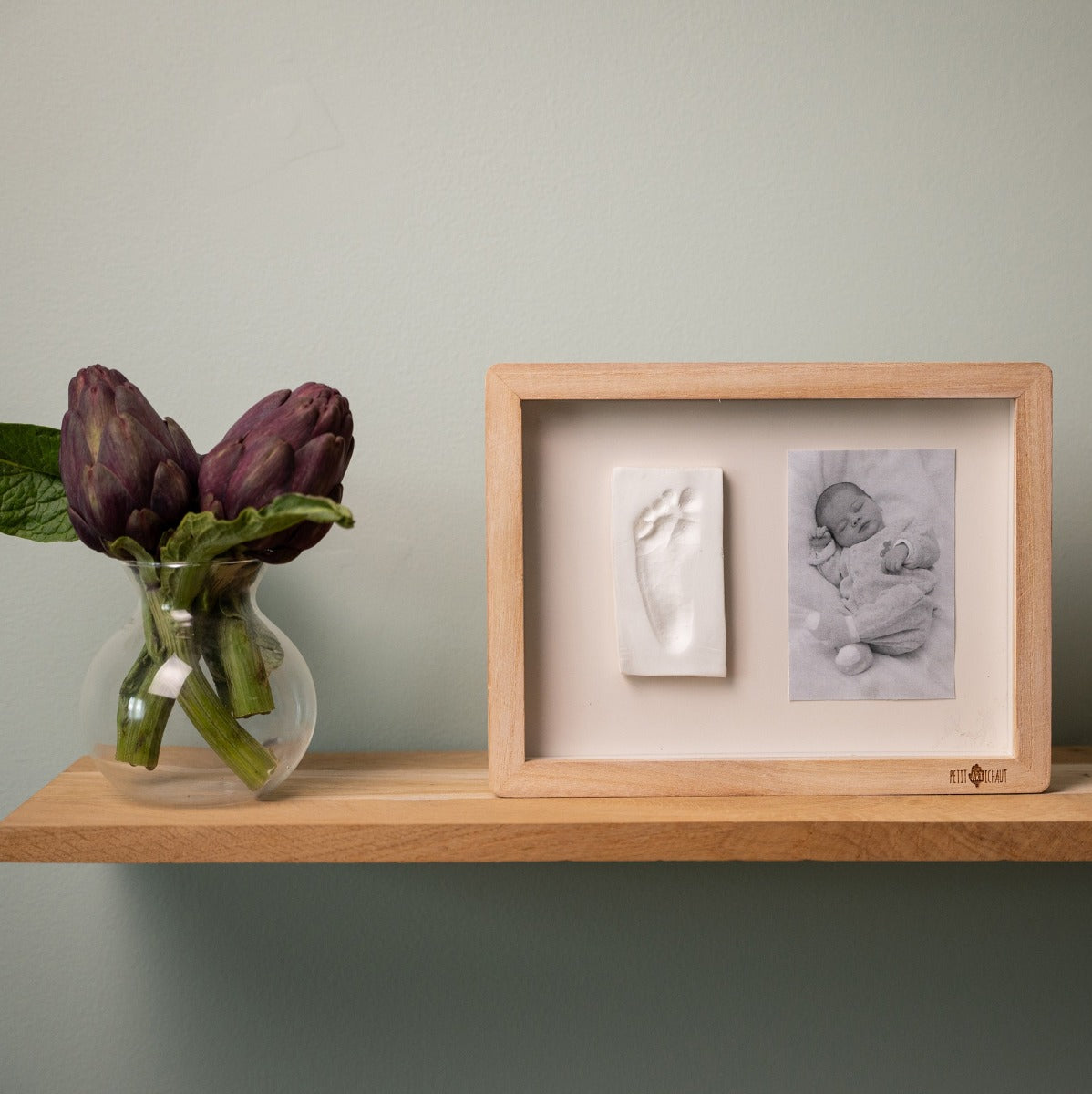 Petit Artichaut Classic frame with Ivy Grey Print placed on a shelf with a plant 