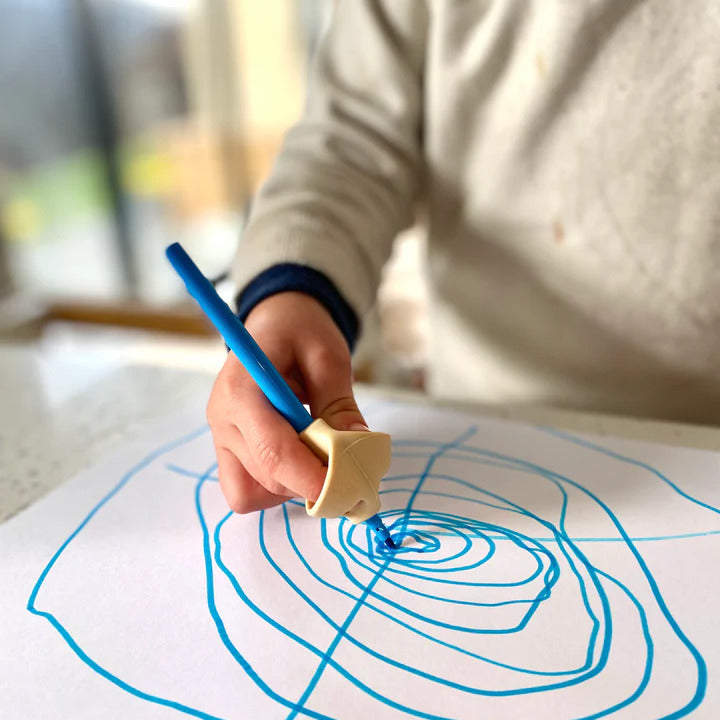 Baby boy drawing with pencil with pencil grip