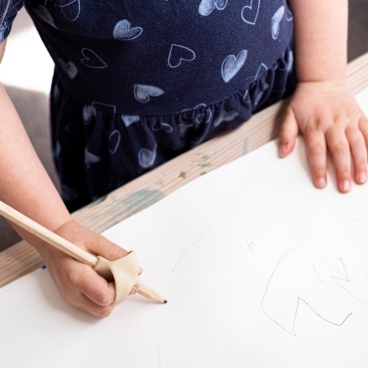 Baby girl drawing with pencil with pencil grip