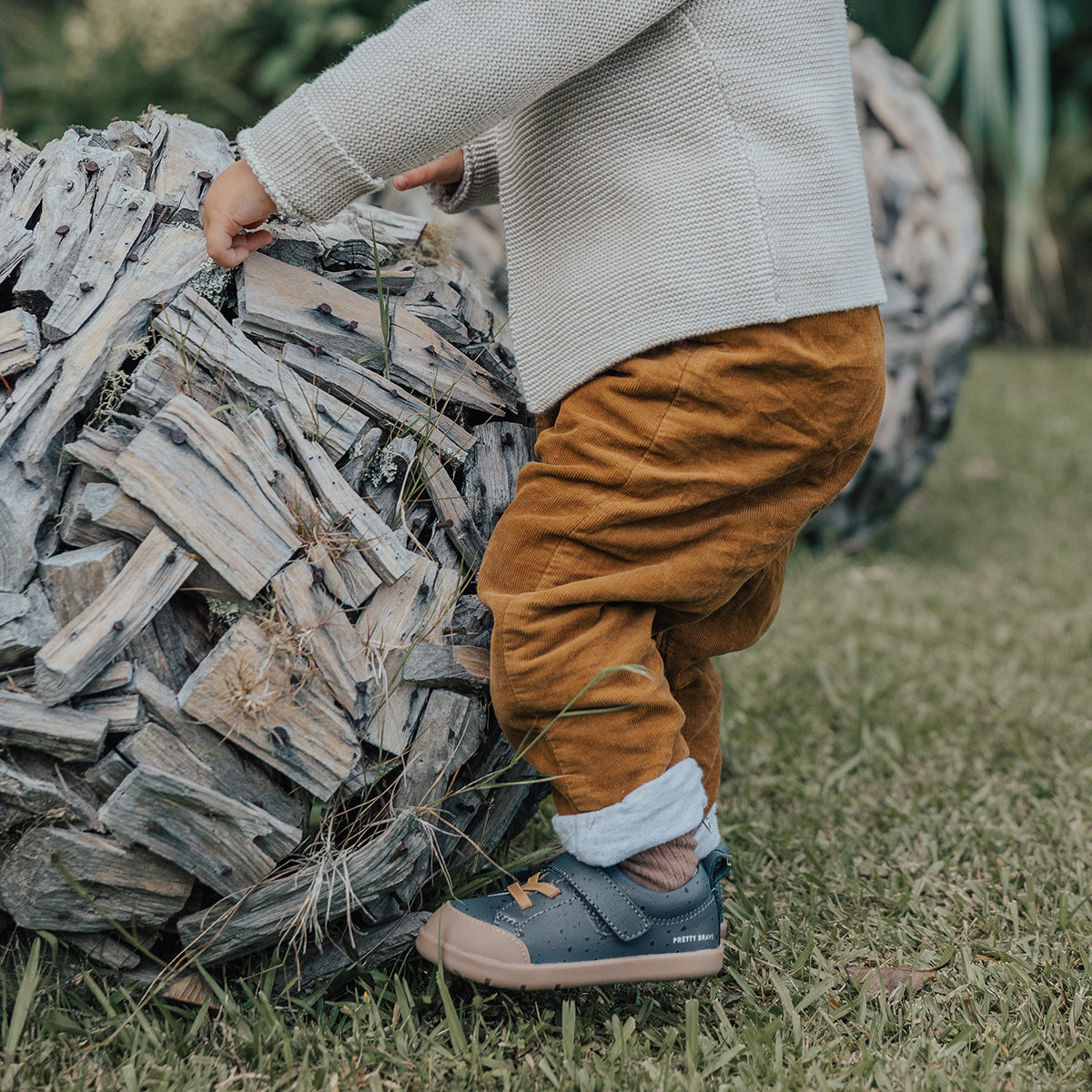 Baby in a park wearing 1st walker indigo shoes