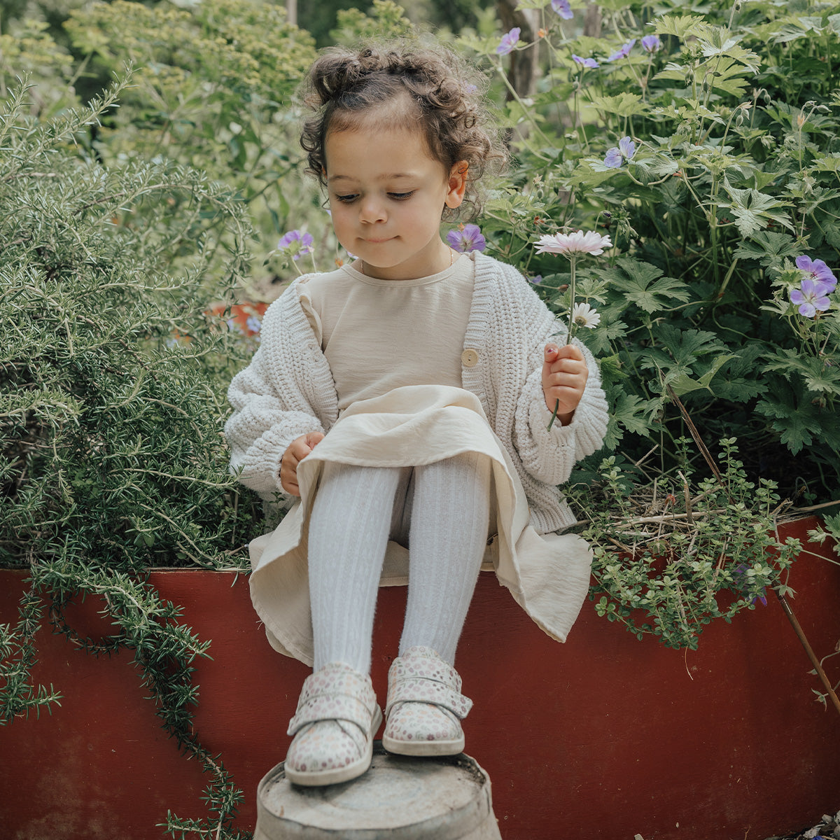 Girl sitting in park wearing Floral print 1st walker shoes