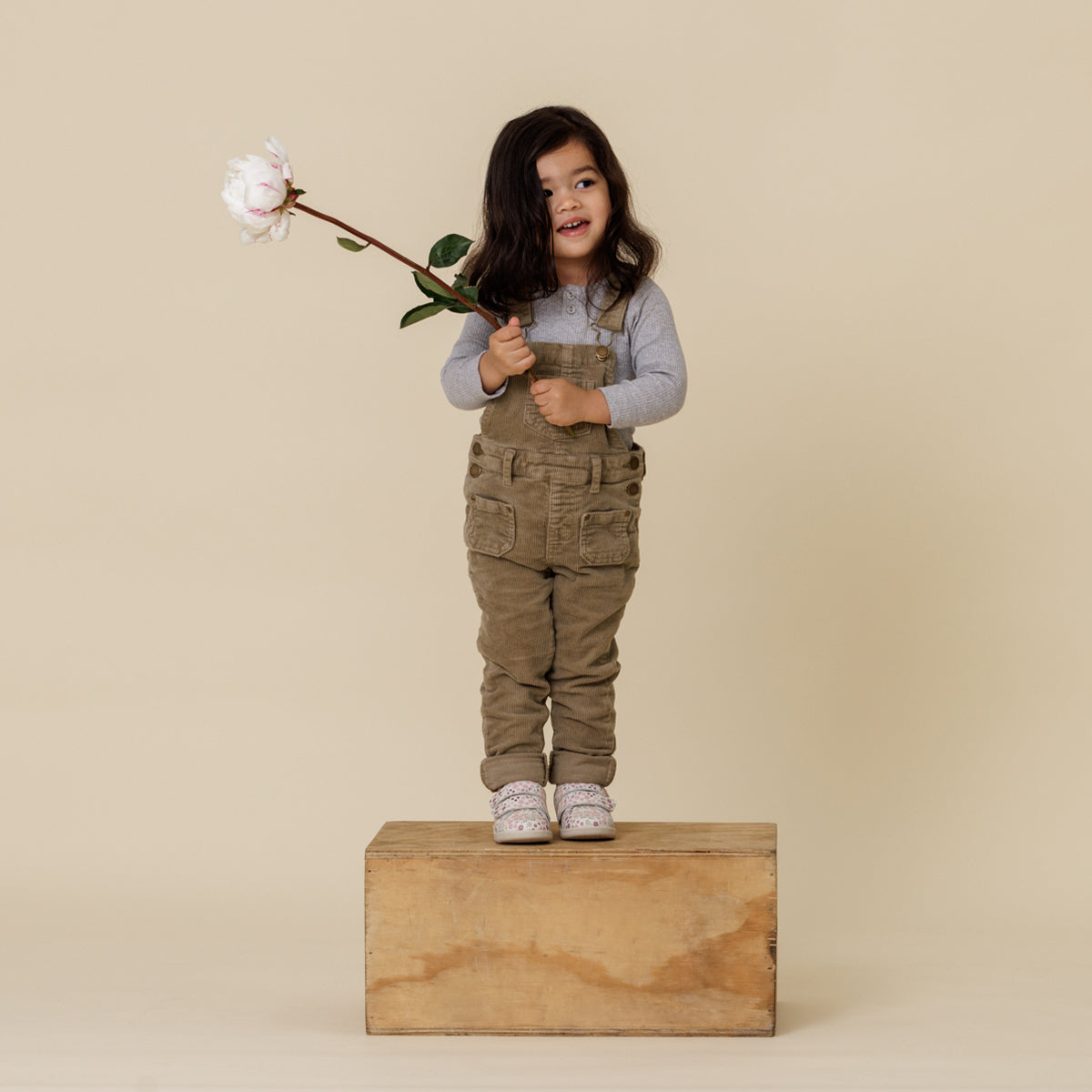 Girl standing on wood block wearing Floral print 1st walker shoes