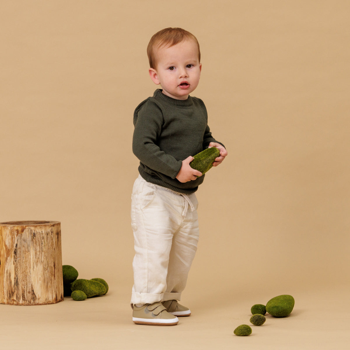 Baby wearing sage leather shoes with Velcro