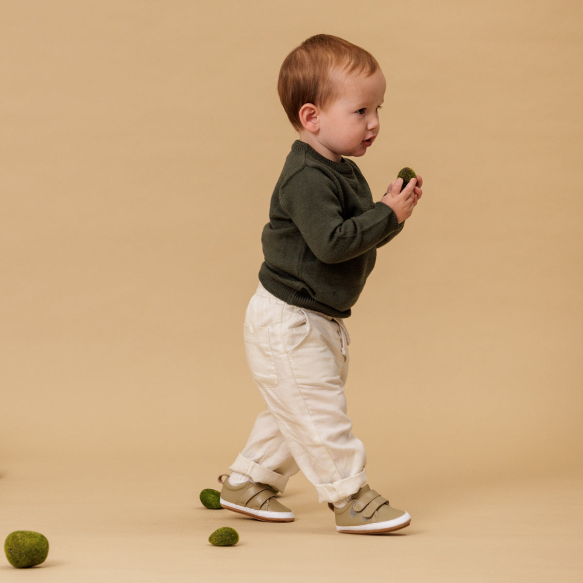Baby wearing sage leather shoes with Velcro