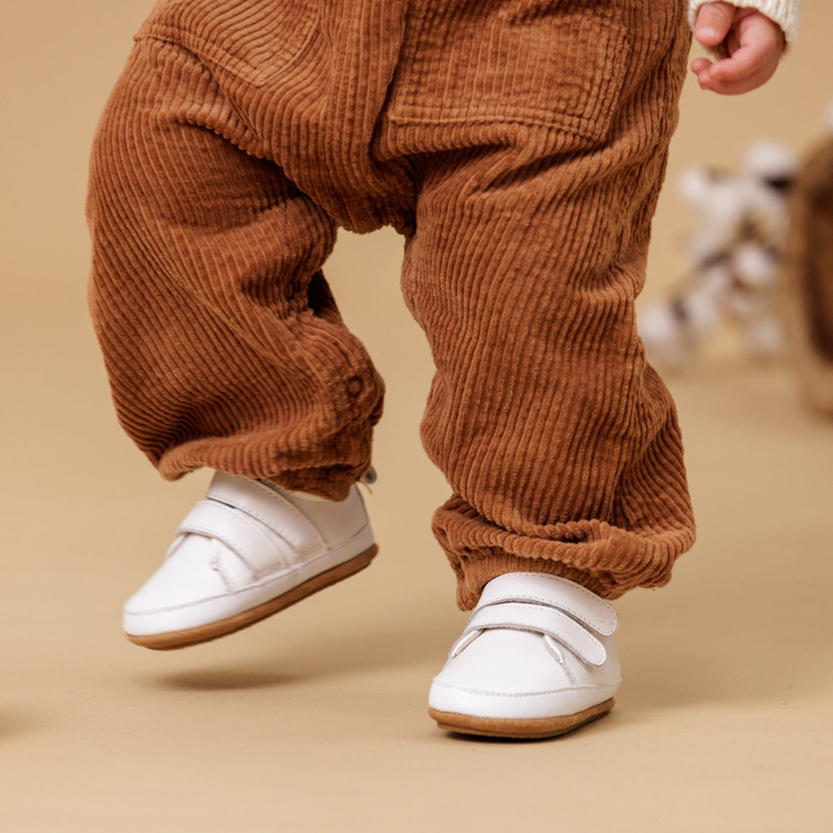 baby wearing white leather shoes