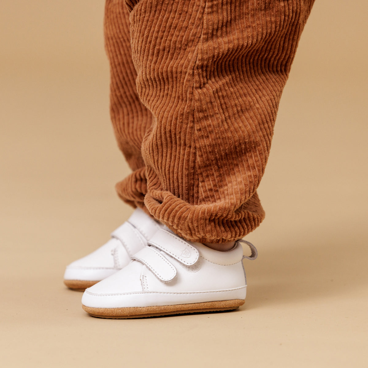 baby wearing white leather shoes