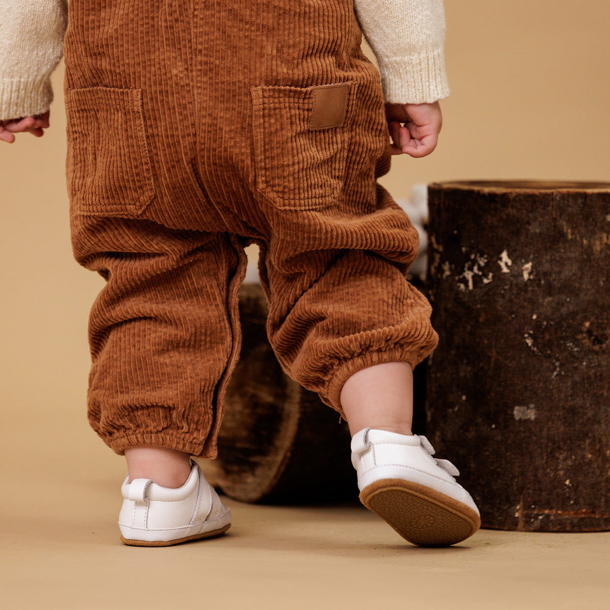 baby wearing white leather shoes