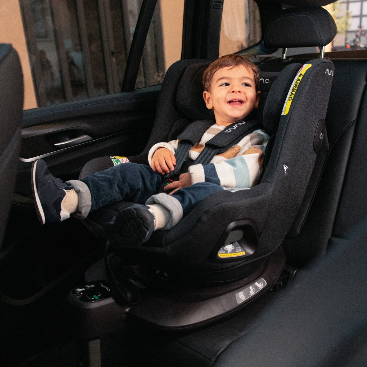 Baby boy sitting in a Pruu car seat in car back seat