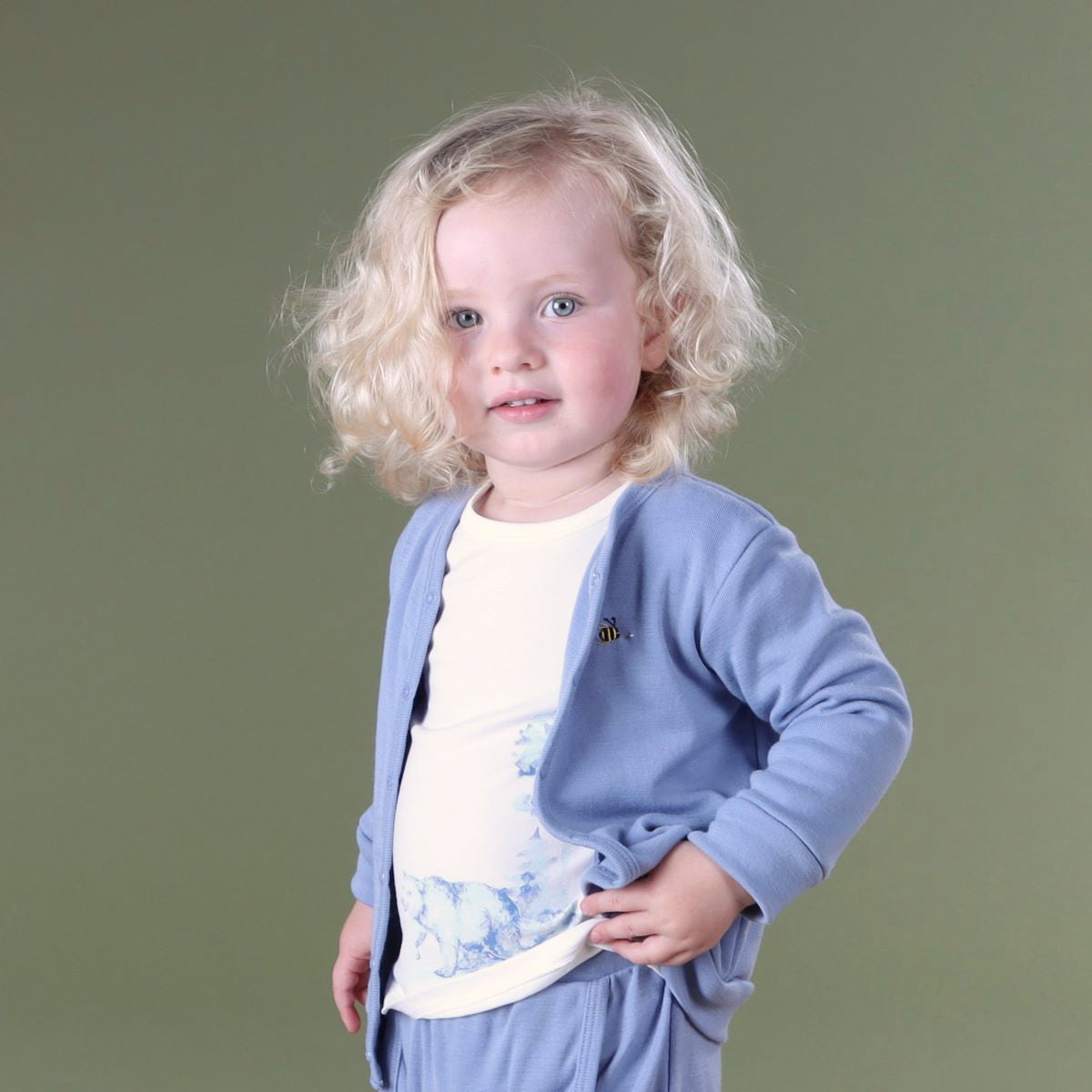 Baby boy standing wearing cotton long sleeve top with blue merino cardigan and pant