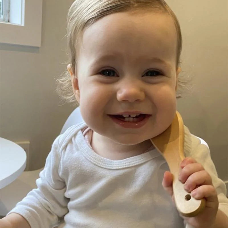 Baby holding Hair Brush from Haakaa