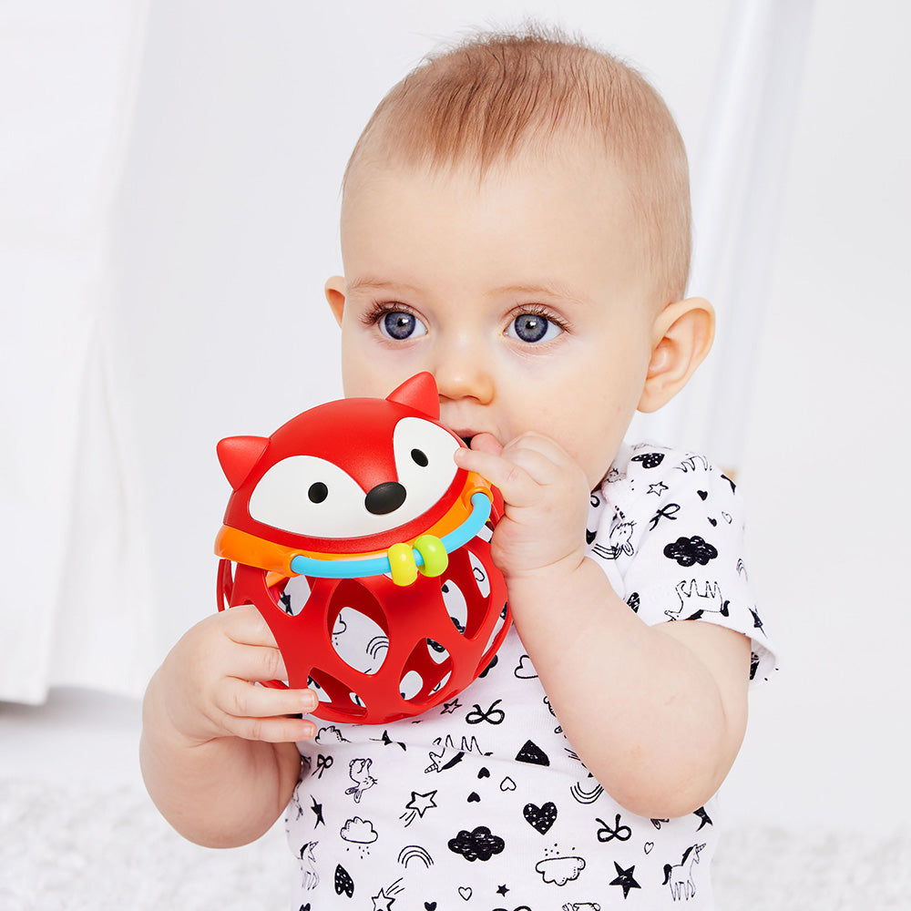 Boy playing with Explore & More Roll Around Rattle - Fox from Skip Hop