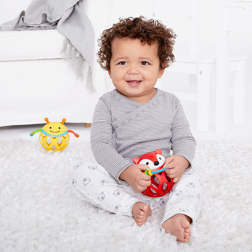 baby boy playing with Explore & More Roll Around Rattle - Fox from Skip Hop
