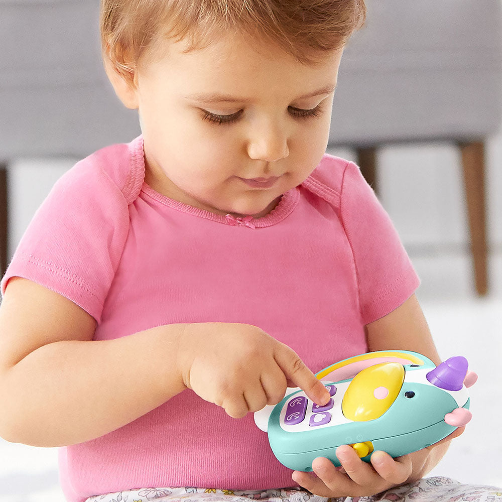 Baby girl playing with Skip Hop Zoo Phone - Unicorn