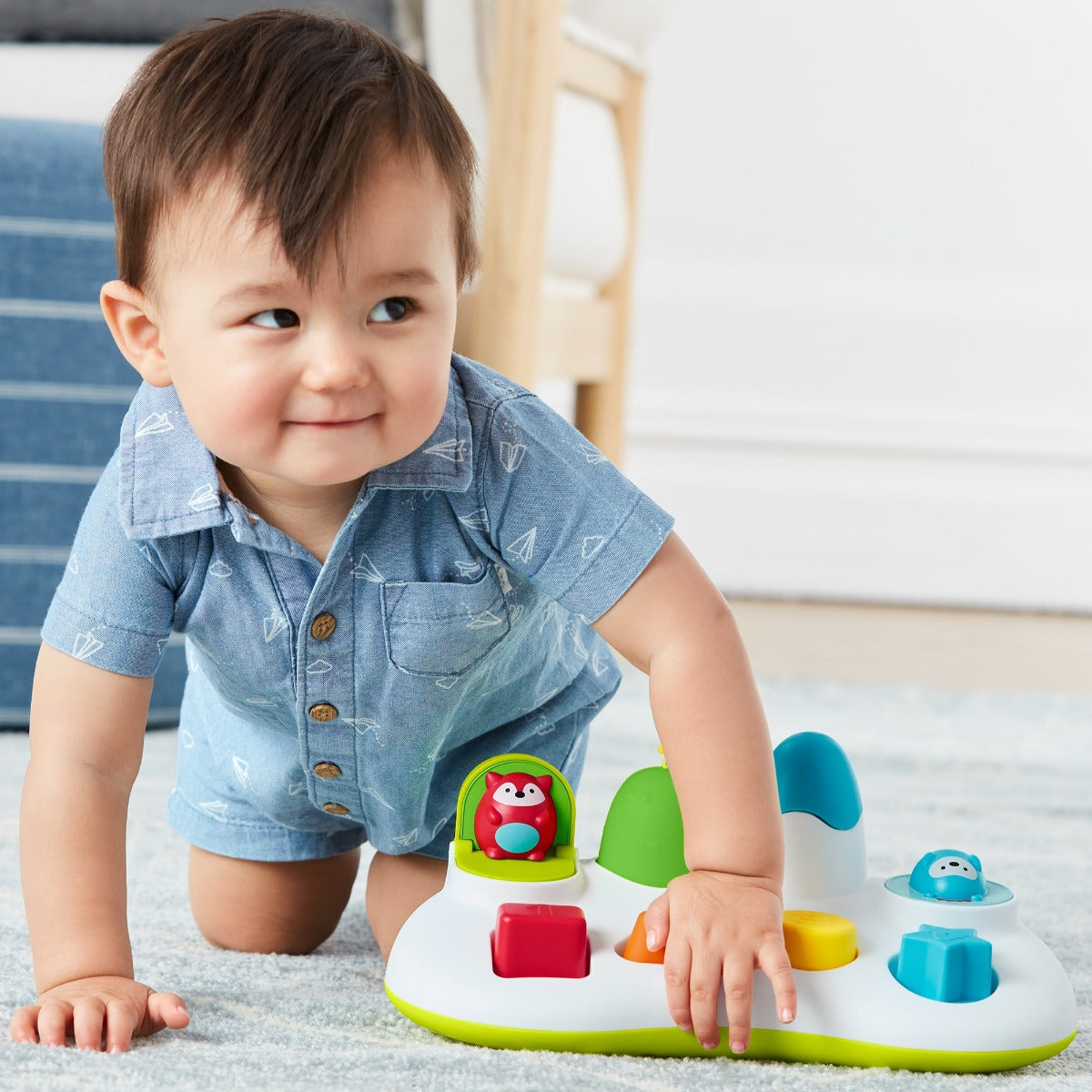 Baby boy playing Explore & More Pop Up Toy from Skip Hop