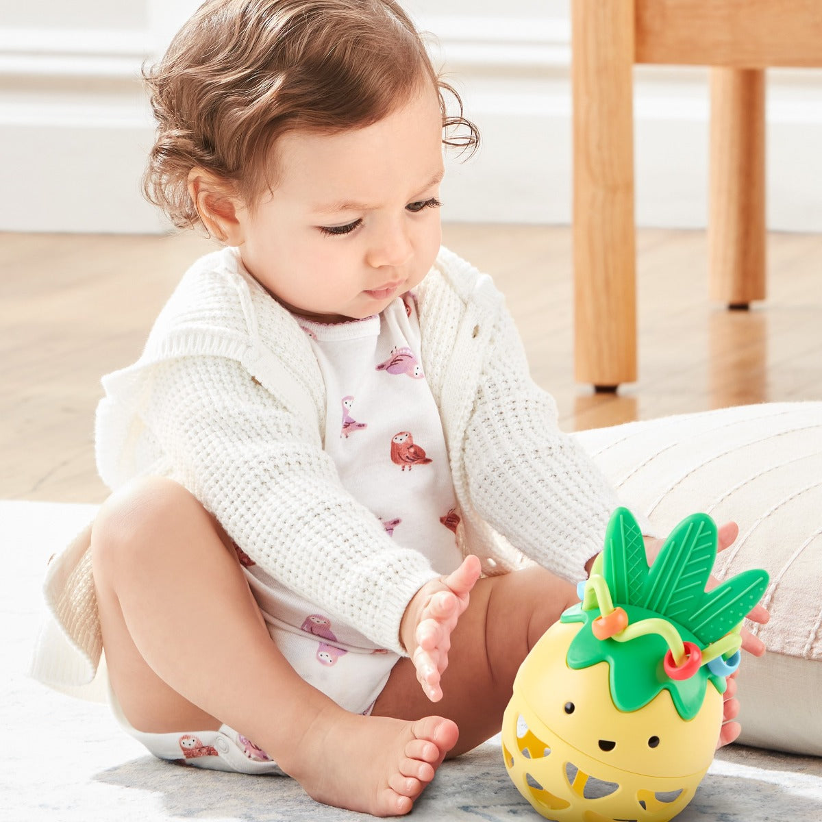 Baby playing with Explore & More Roll Around Rattle - Pineapple from Skip Hop