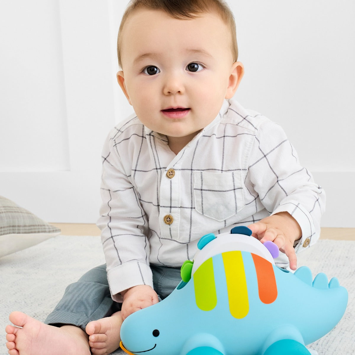 Baby playing with Skip Hop Explore & More Dinosaur 3-In-1 Baby Musical Pull Toy