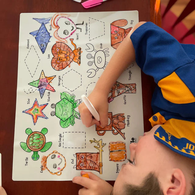 Boy colouring on HeyDoodle reusable silicone colouring and doodle mat with geometrical shapes in animals