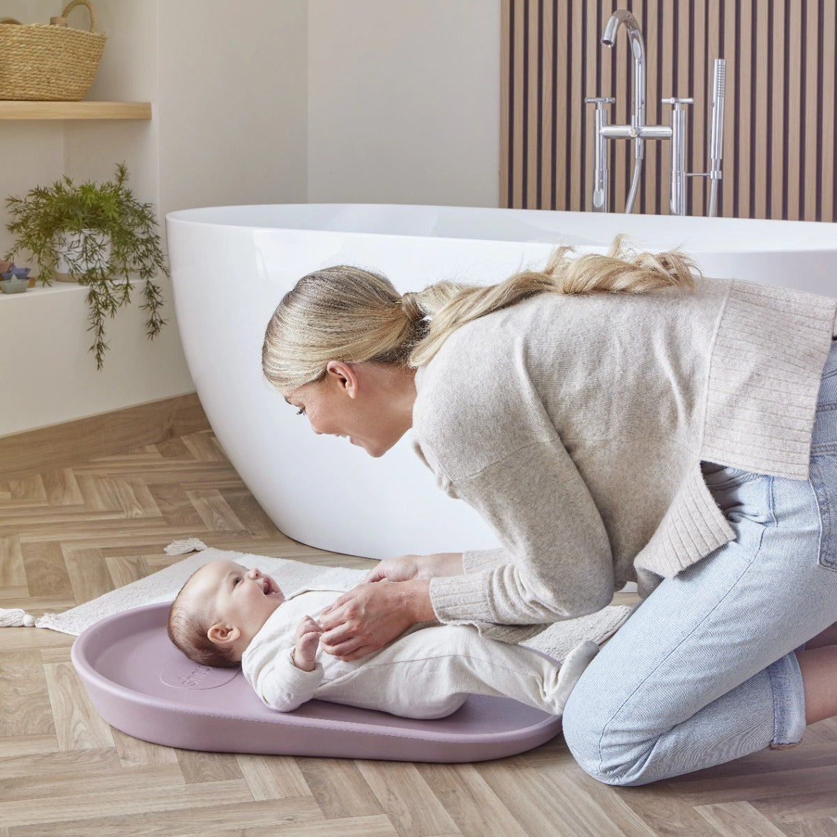 Mother changing nappy of baby on Shnuggle Squishy, baby nappy change mat in Blossom
