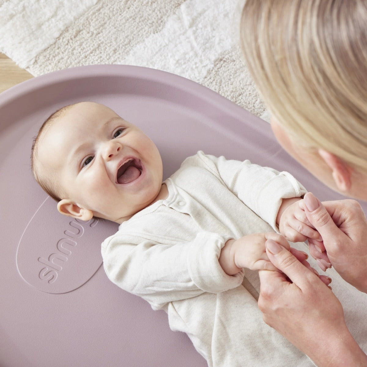 Baby in Shnuggle Squishy, baby nappy change mat in Blossom