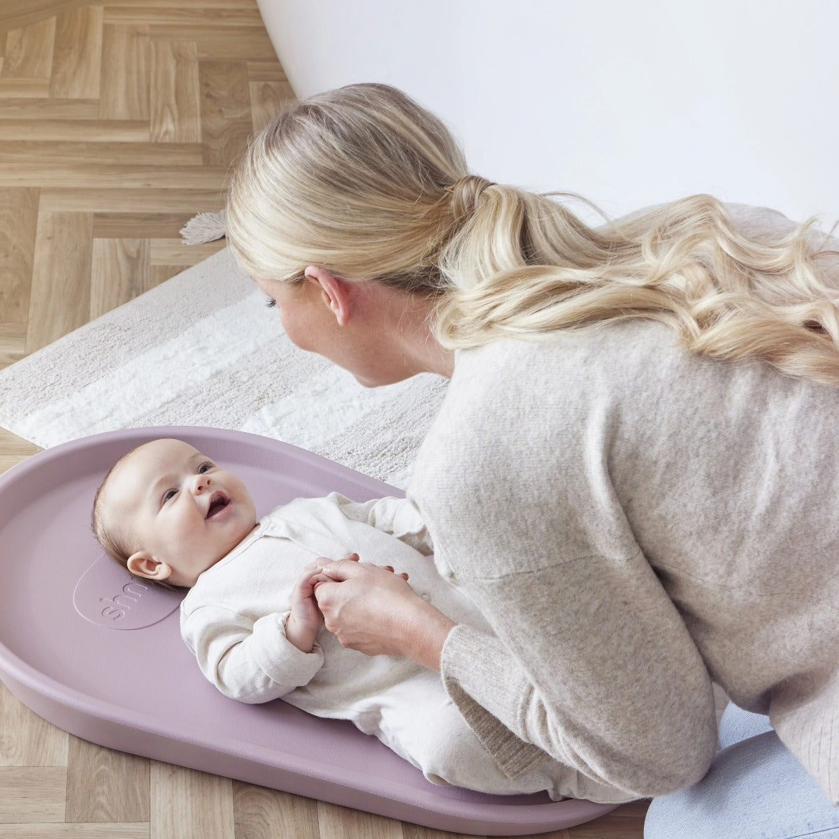 Mother changing baby nappy in Shnuggle Squishy, baby nappy change mat in Blossom