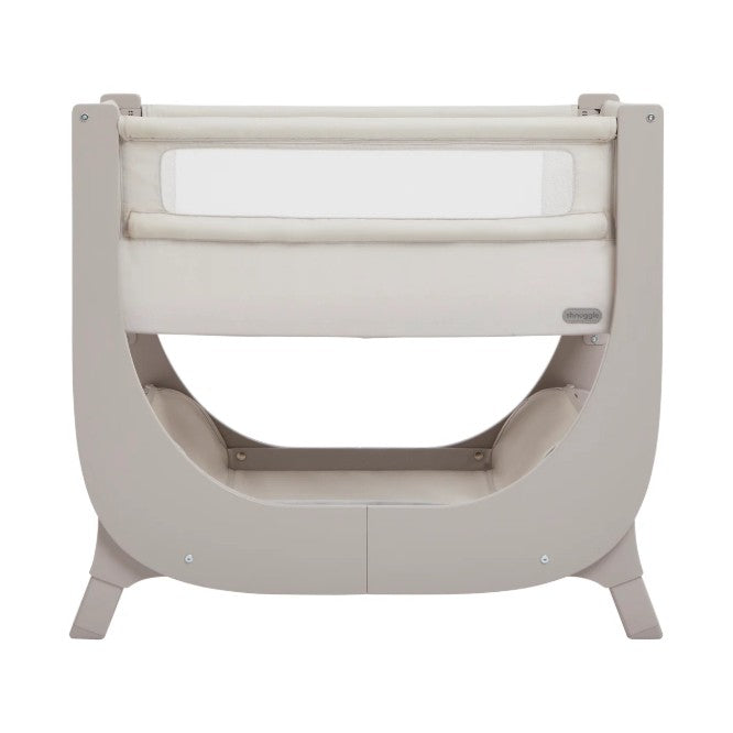 Beige baby crib with white mattress on a white background