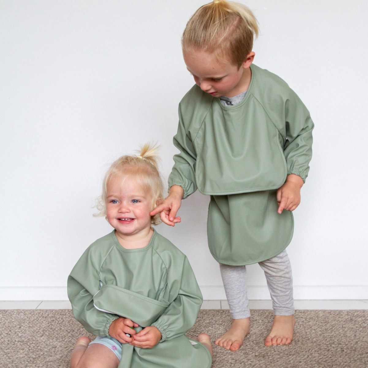 Babies wearing recycled polyester sleeved bib