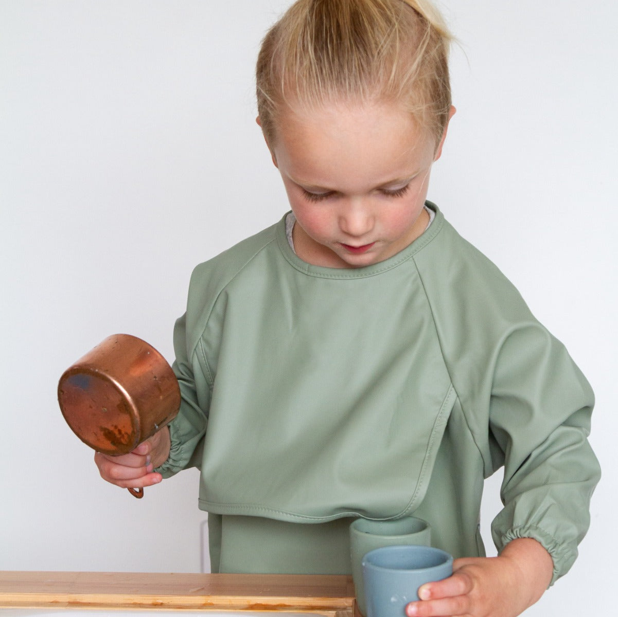 Baby girl playing wearing recycled polyester sleeved bib