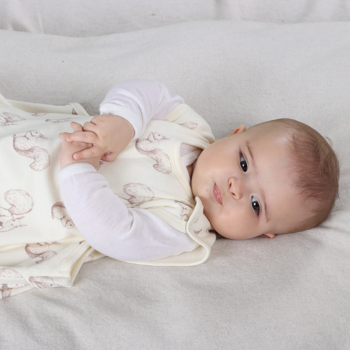 Little Bee by Dimples Merino Lined Sleeping Bag in Squirrel Print on a baby lying down