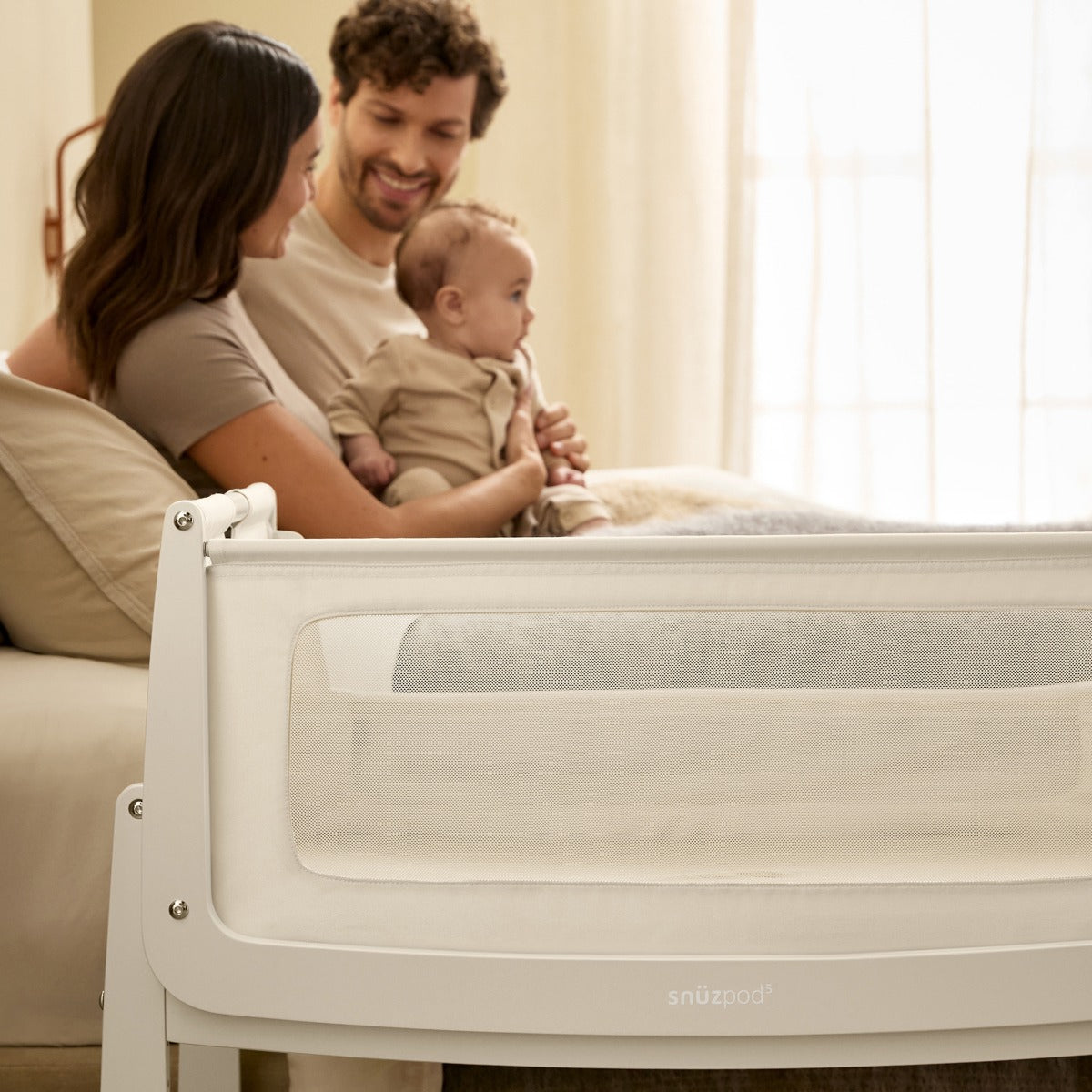 Snuzpod 5 Cashmere Wood Frame Bedside Baby Crib in room with parents and baby
