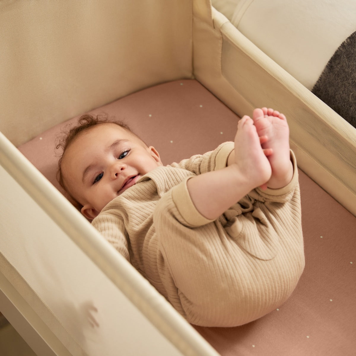 Baby sleeping in Snuzpod 5 White Wood Frame Bedside Baby Crib in Cashmere