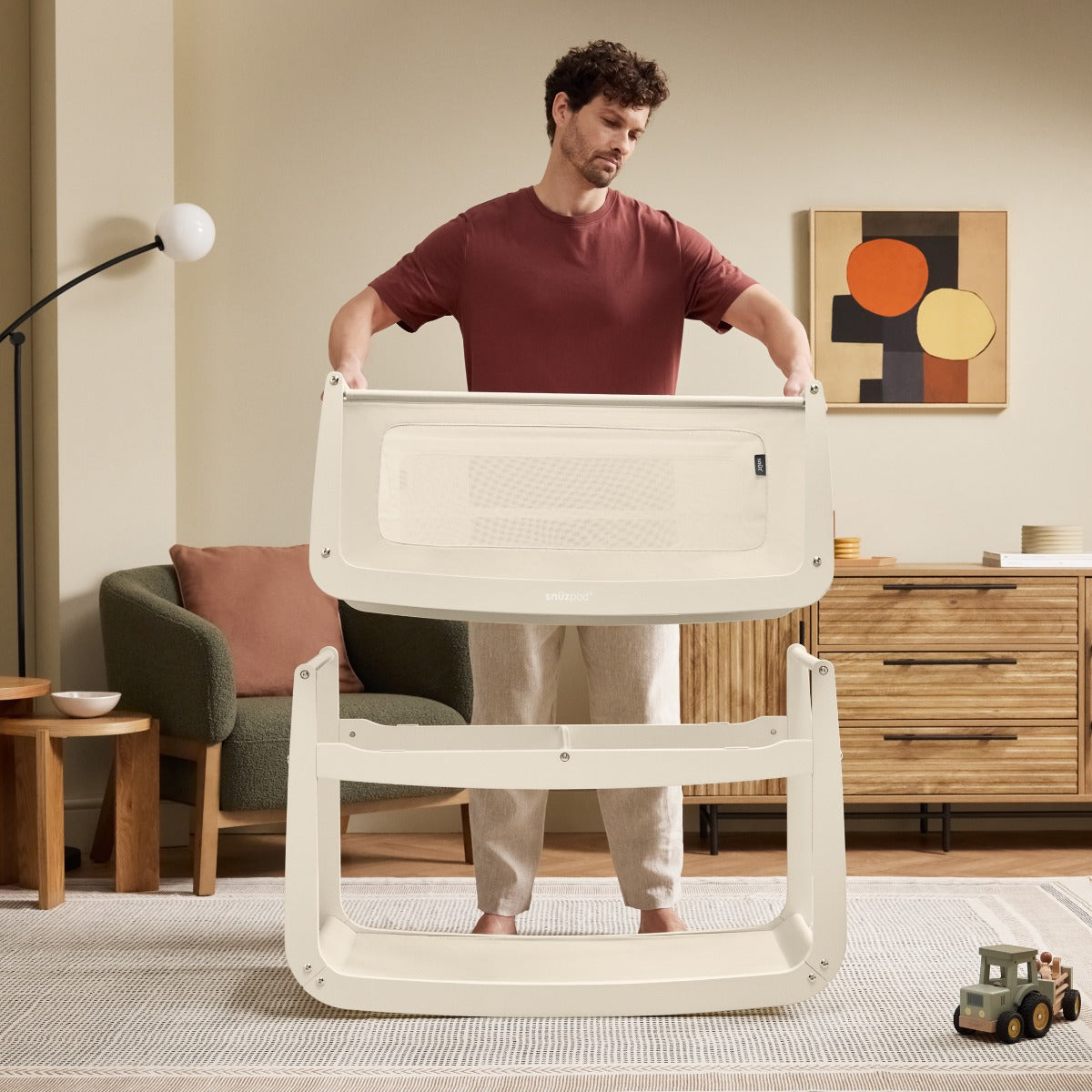 Father pulling crib of Snuzpod 5 Cashmere Wood Frame