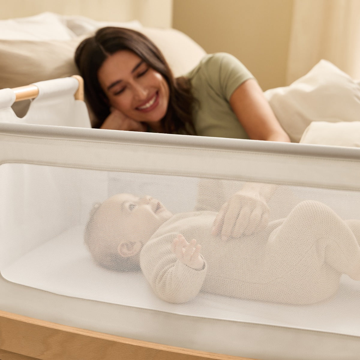 Baby sleeping in Snuzpod 5 Natural Wood Frame Bedside Baby Crib