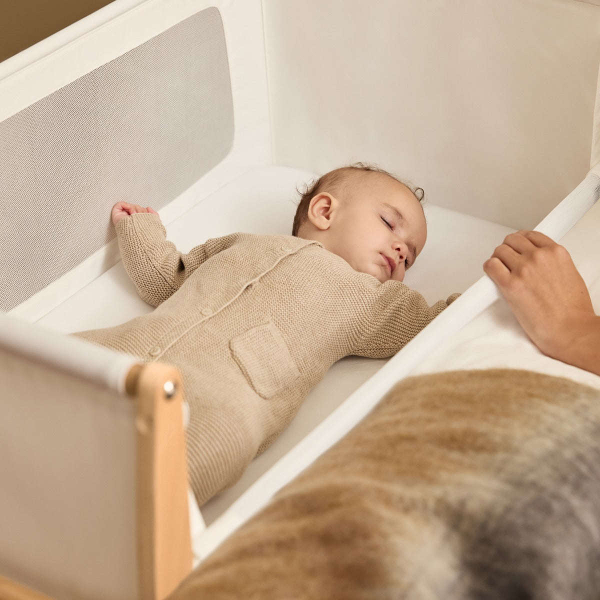 Baby sleeping in Snuzpod 5 Natural Wood Frame Bedside Baby Crib