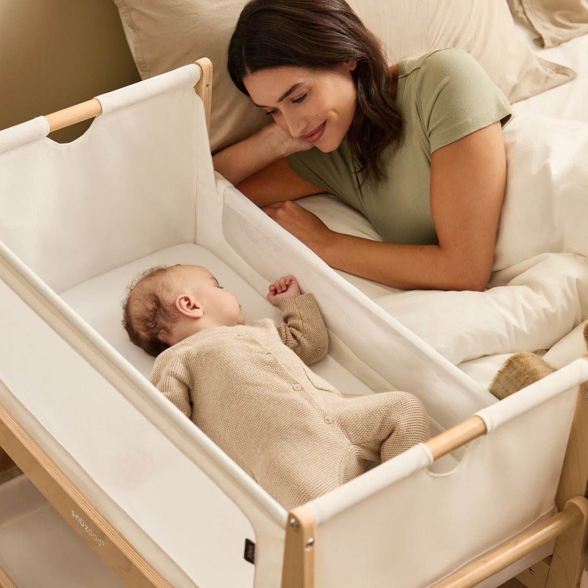 Baby sleeping in Snuzpod 5 Natural Wood Frame Bedside Baby Crib