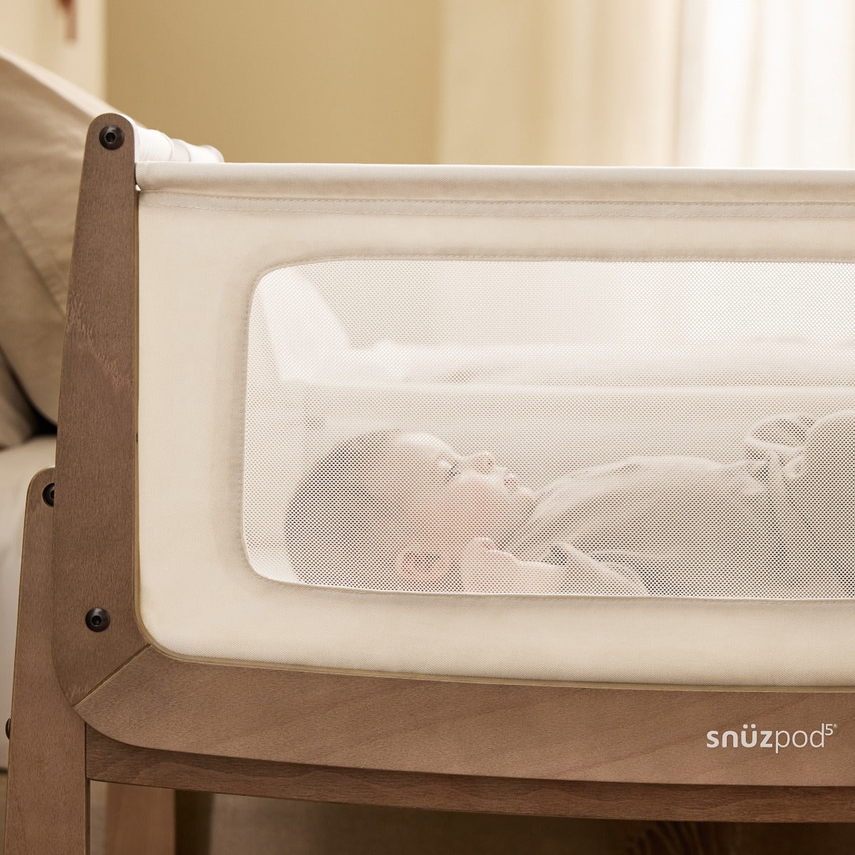 Baby sleeping in Snuzpod 5 Walnut Wood Frame Bedside Baby Crib