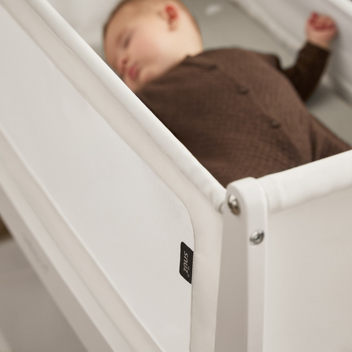 Baby sleeping in Snuzpod 5 White Wood Frame Bedside Baby Crib