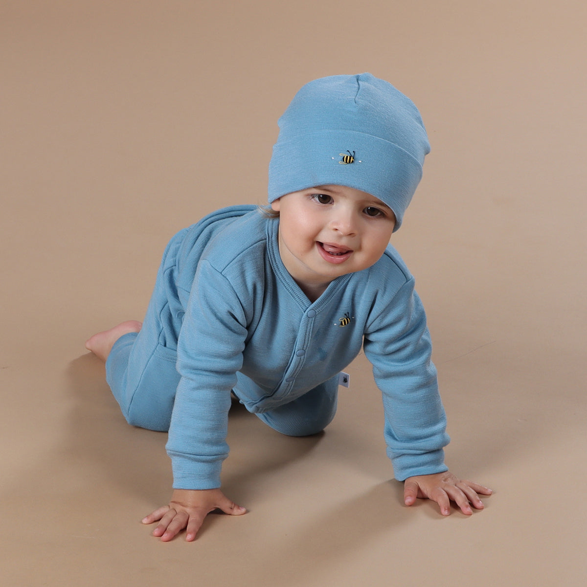 Baby wearing merino wool beanie, cardigan and pants.