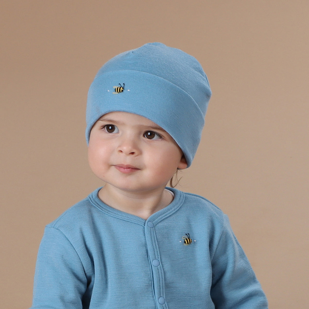 Baby wearing merino wool beanie, cardigan.