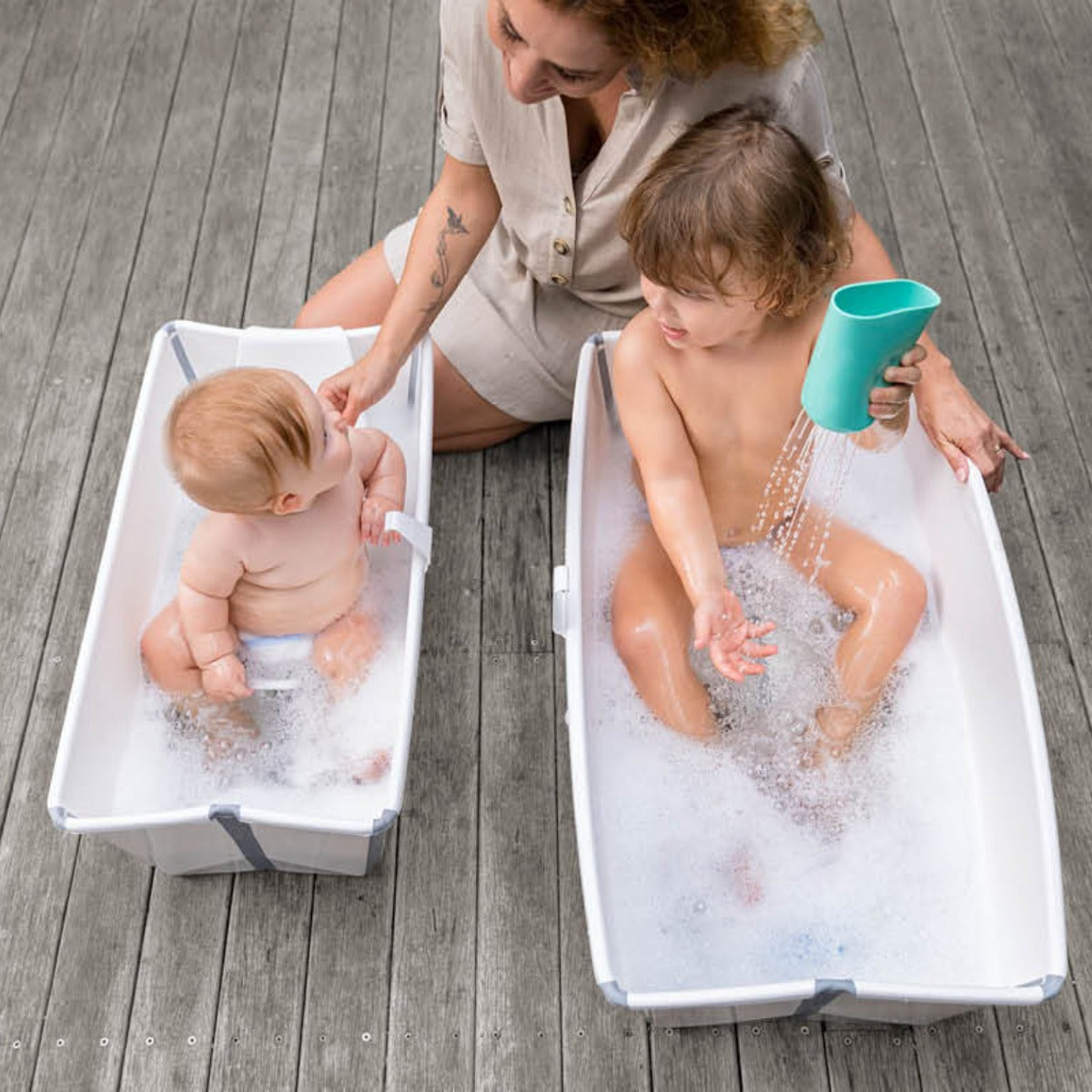 Stokke XL Flexi bath in white lifestyle of both sized baths with babies