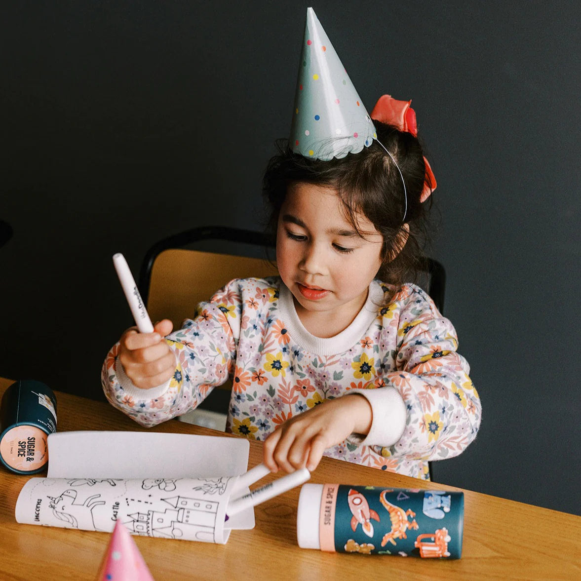 Girl coloring on silicone activity mat wearing birthday hat