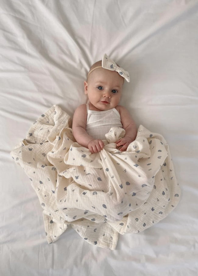 Happy toddler with Swaddle Enchanted Garden Over the Dandelion