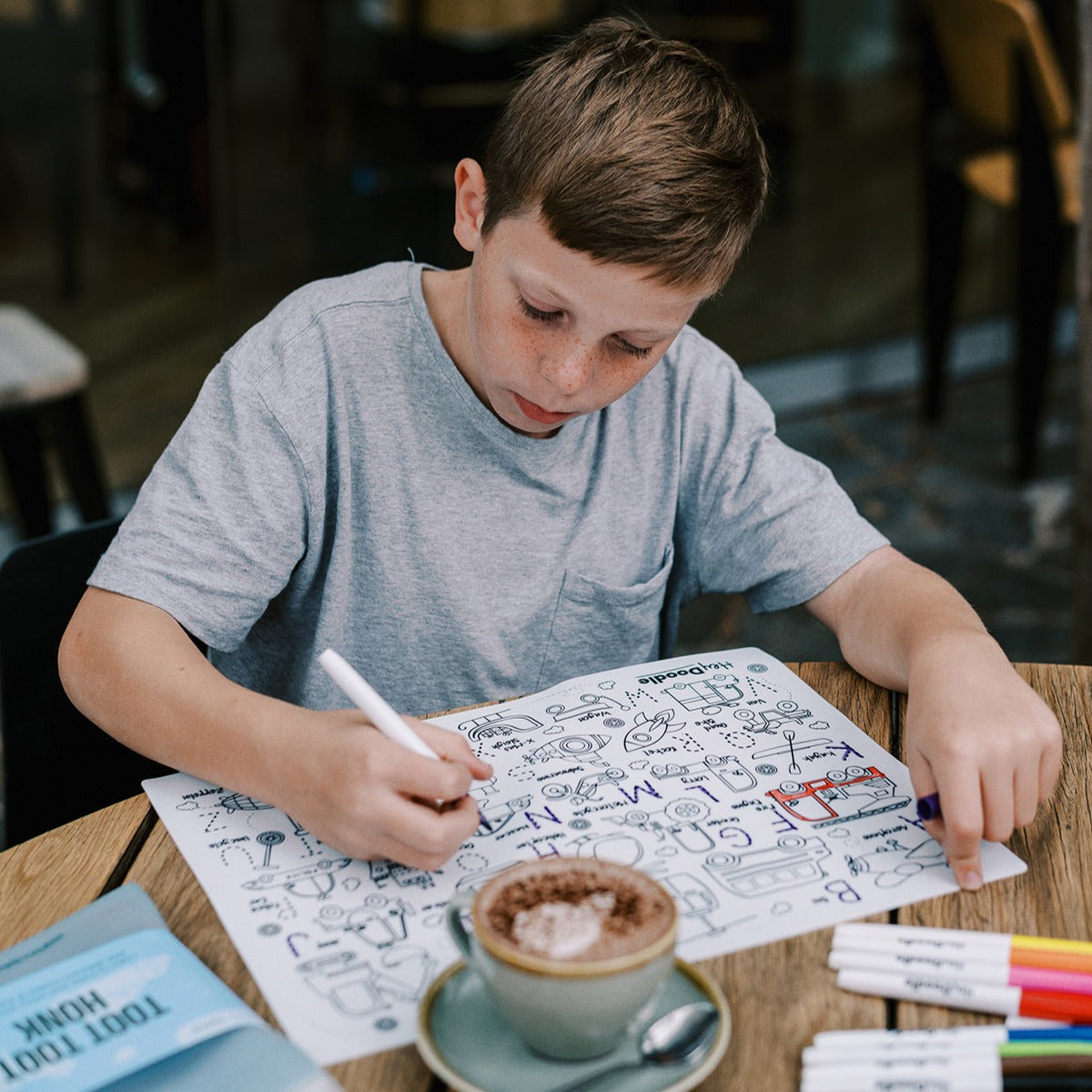 Boy colouring on HeyDoodle reusable silicone activity minimat with vehicles 