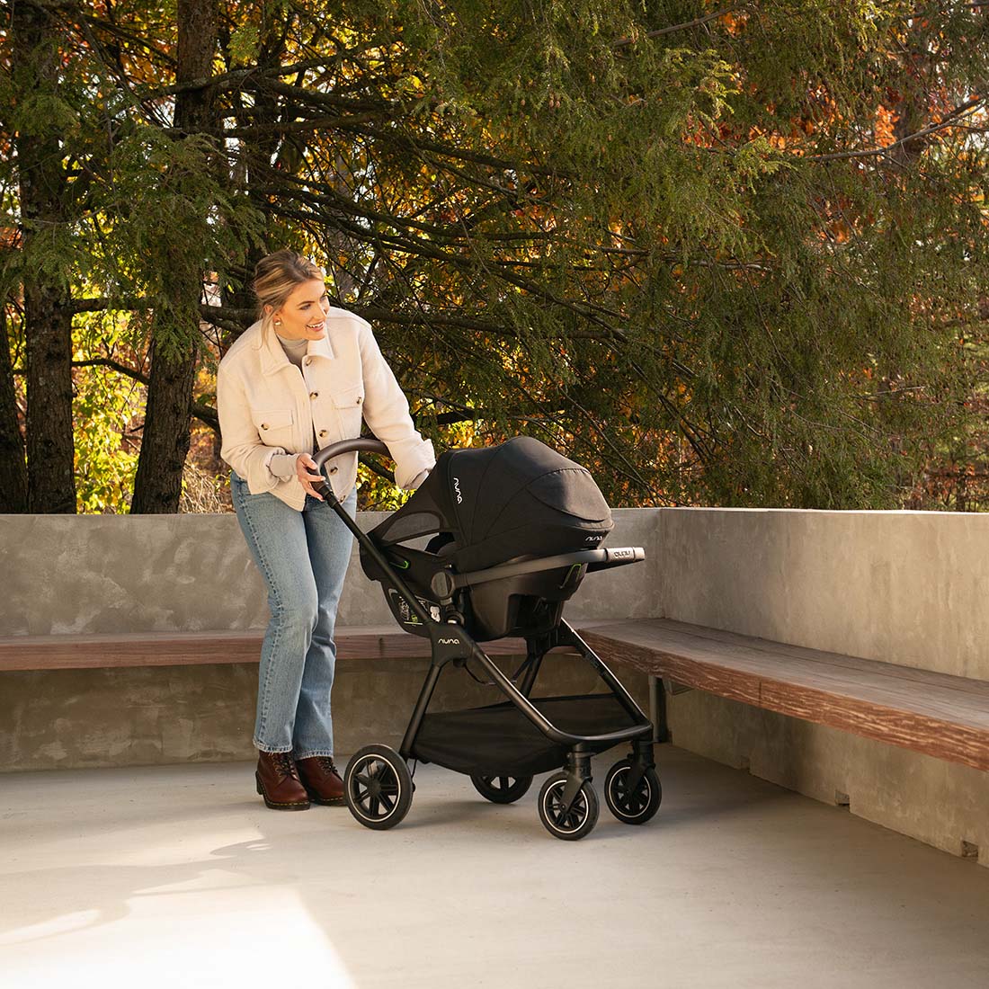 Mother standing with Nuna Triv Next Caviar pram side view attached with Pipa capsule