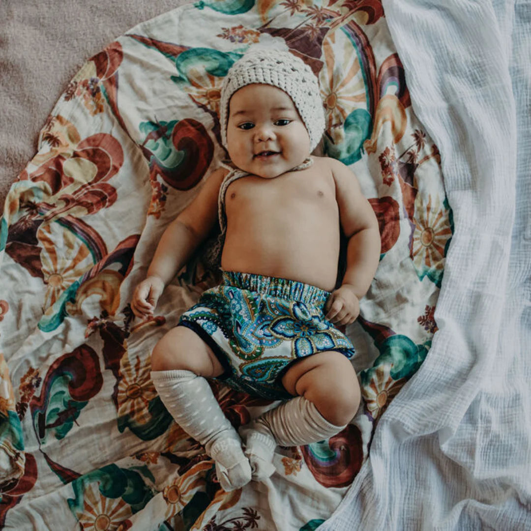 Baby lying on swaddle wearing Merino Wool Kneehigh socks for baby from Lamington