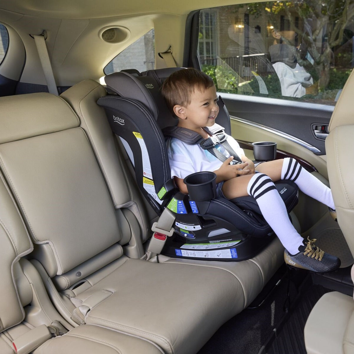 Baby boy happily seating in Poplar S car seat in stone onyx from Britax
