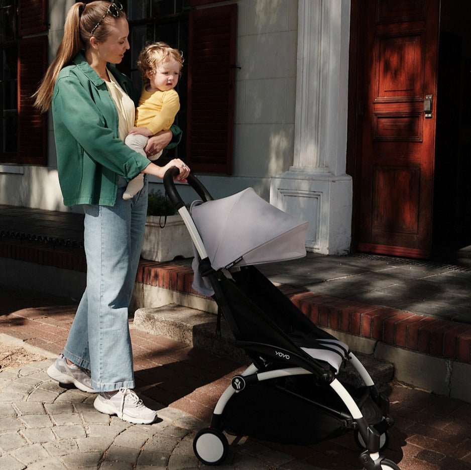 Mother walking with YOYO3 Stroller 6+ colour pack and holding baby
