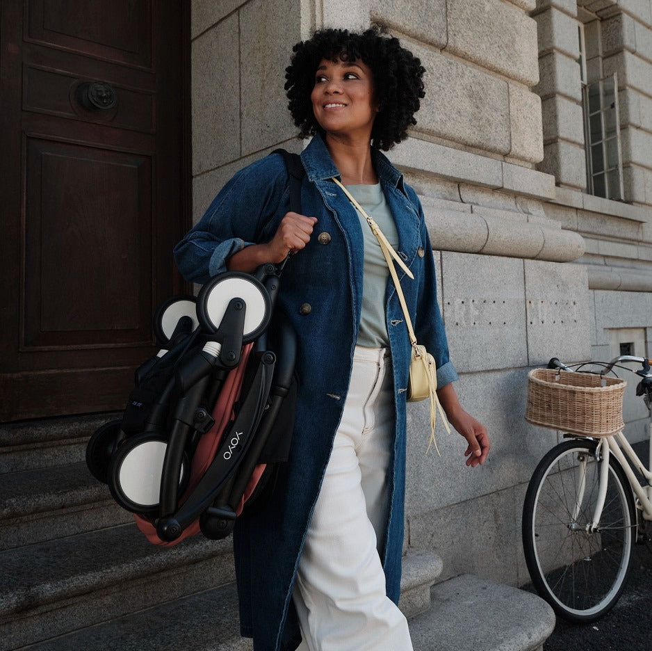 Mother carrying folded YOYO pram 