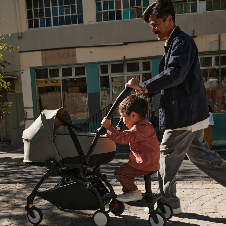 Father walking on road with YOYO3 pram with 2 kids